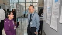 Pediatric resident talks to her program director at a research poster exhibit.
